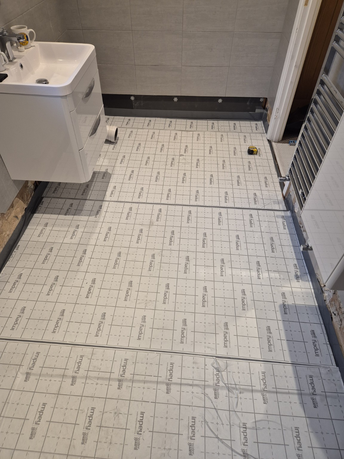Waterproofing membrane laid across the wet room floor